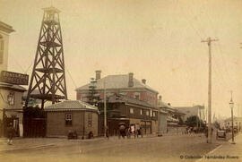 Yokohama (Japón), una calle con el Hotel Concordia de estilo occidental, una torre de vigilancia y varios rickshaws. Fotógrafo desconocido