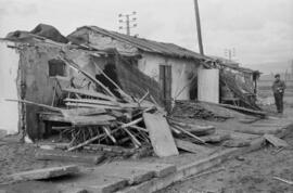 Hombre junto a una chabola destrozada como consecuencia del temporal de viento en las playas de El Bulto y San Andrés. Málaga. Enero de 1963