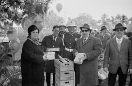 Los vespistas entregando aguinaldo a los guardias municipales en calle Larios de Málaga. Diciembre de 1963